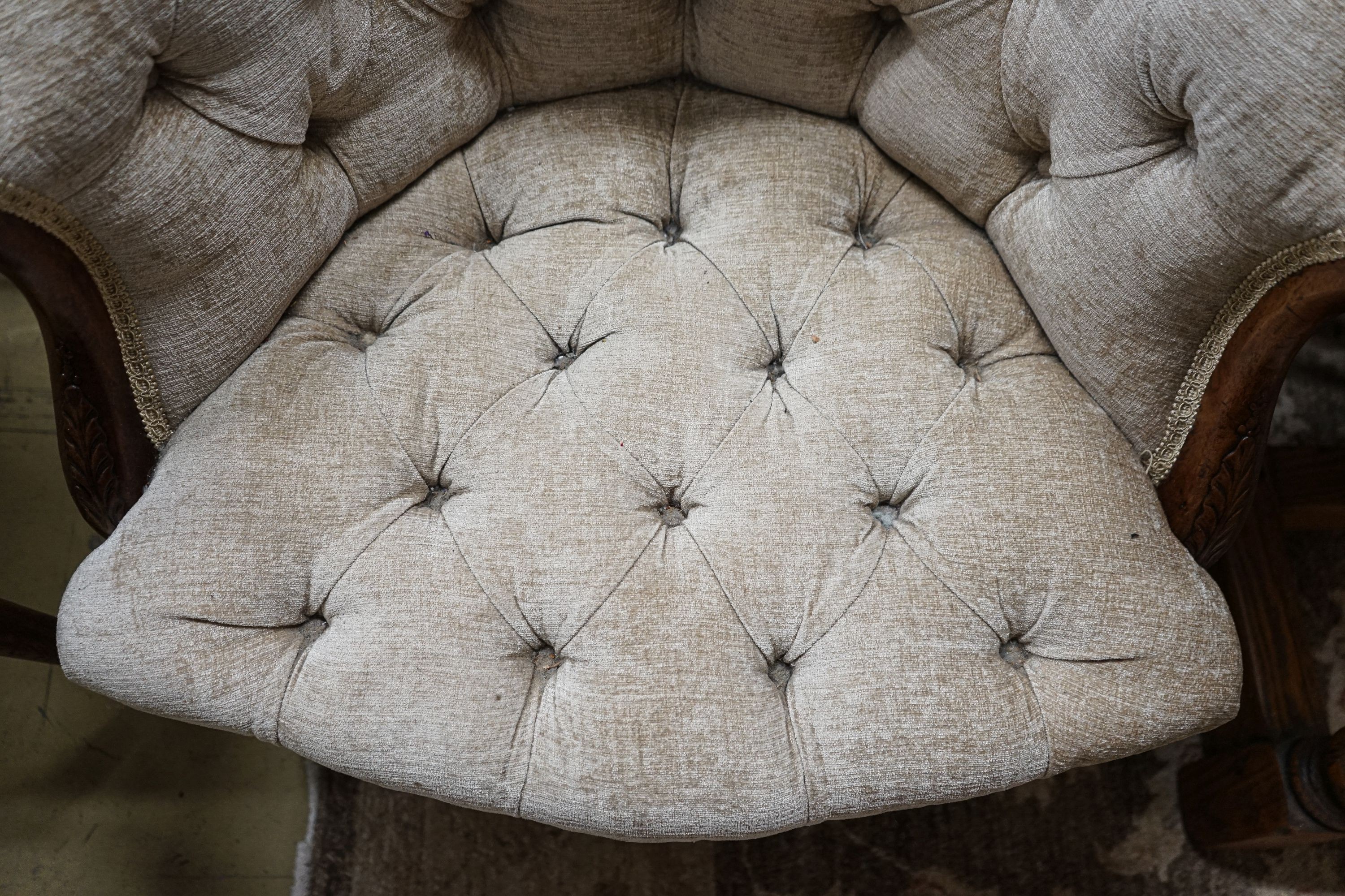 A George III Hepplewhite style mahogany tub chair, with later buttoned upholstery, acanthus carved arms and chamfered moulded squared legs, fitted brass castors, width 64cm, depth 50cm, height 97cm
